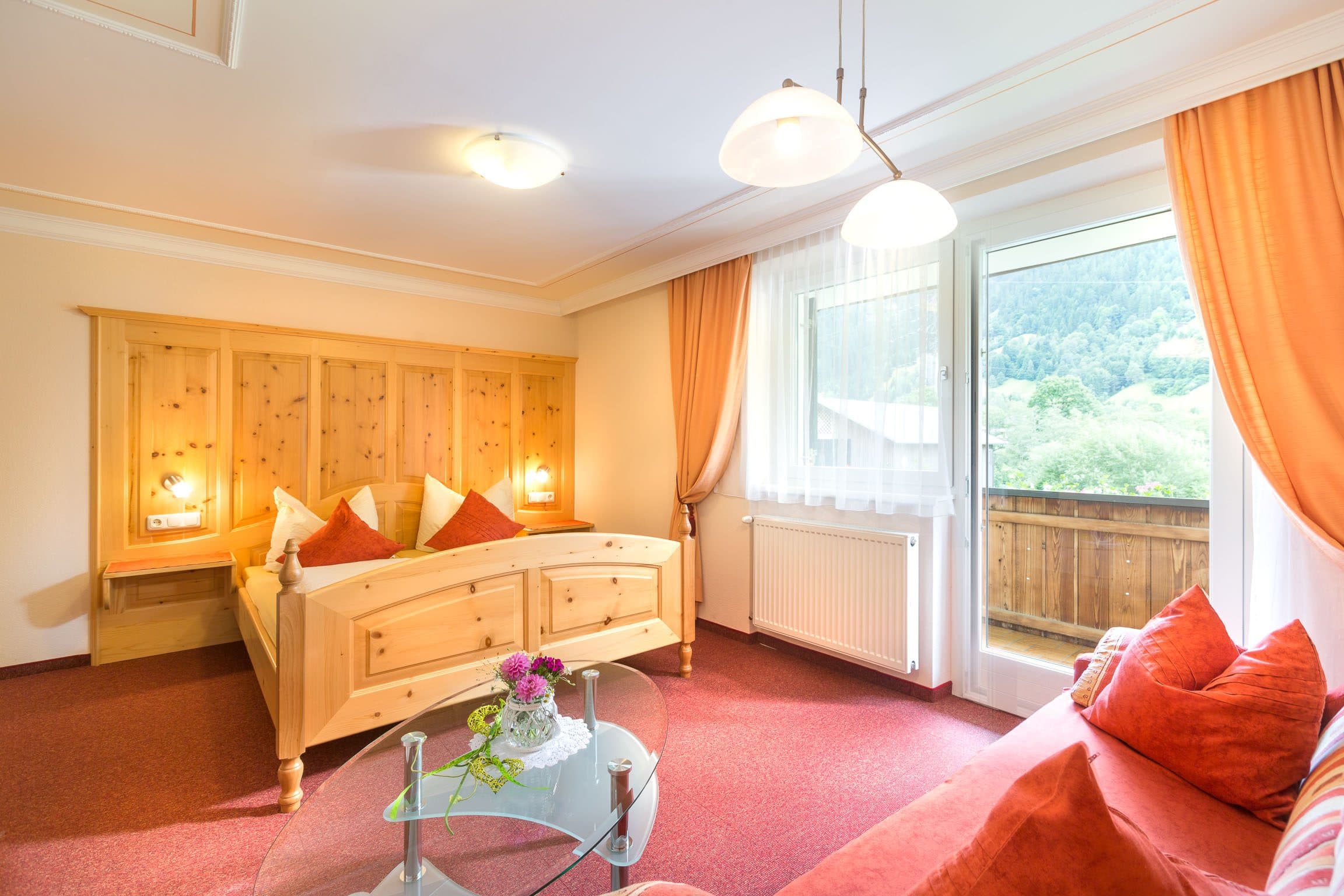 Gemütliches Schlafzimmer mit Holzbett und Blick ins Grüne in der Ferienwohnung Landhaus Angelika